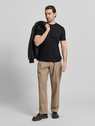 Männermodel trägt Regular Fit T-Shirt mit Rundhalsausschnitt von Emporio Armani in Schwarz, kurzärmelig, Ganzkörperansicht von vorne.
