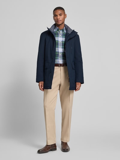 Männermodel trägt Jacke mit Stehkragen und Pattentaschen von Christian Berg Men in Dunkelblau; glatte Textur, Ganzkörperansicht von vorne. Regular Fit, verdeckter Reißverschluss, Brusttasche, Pattentaschen. Rückenlänge 84 cm, Schulterbreite 51 cm, Brustweite 56 cm, Ärmellänge 66 cm.