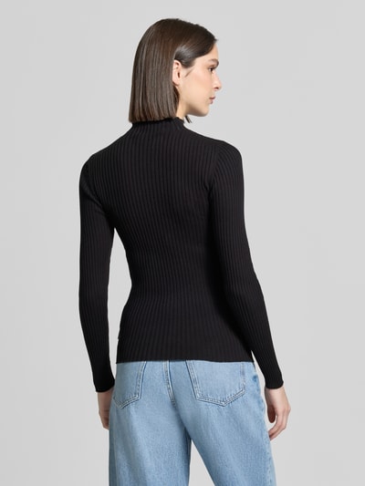 Vrouwenmodel draagt Slim Fit gebreide pullover uit puur katoen model 'ALAANIA' van Armedangels, look: effen, lange mouw, hooggesloten, labelpatch, logostitching, tricot, detailopname, rugaanzicht.