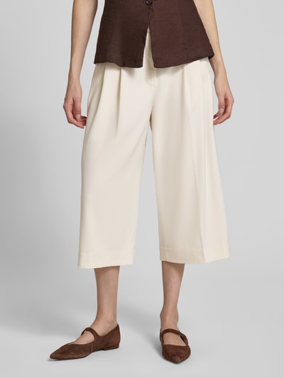 Kobiece modelka nosi kuloty z mieszanki materiałów z dodatkiem wiskozy Copenhagen Muse, model 'TAILOR', wpuszczane kieszenie, krój wide leg fit, zaszewki, kolor kremowy, zapięcie na haftkę i zamek błyskawiczny, szerokość w rozmiarze S: 39 cm, długość wewnętrzna nogawki w rozmiarze S: 50 cm, widok całej sylwetki z przodu.