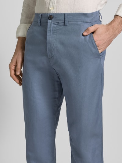 Męski model nosi Regular Fit Leinenhose aus Baumwoll-Leinen-Mix Modell 'MILES' von SELECTED HOMME, niebieska, materiał gładki, 5 kieszeni, krój regular fit, średni stan, guzik i zamek, widok z przodu, zbliżenie na górną część.