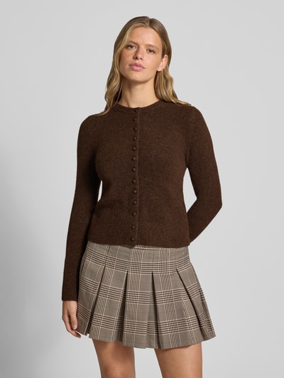 Modelka kobieca ma na sobie Slim Fit Strickjacke mit Woll-Anteil Modell 'Sia' od Topshop, brązowy sweter z długim rękawem, prążkowane ściągacze, zapięcie na guziki, melanżowa tekstura, materiał elastyczny z domieszką wełny, połączony z plisowaną spódnicą w kratę, widok całej sylwetki z przodu.
