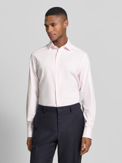 Männermodel trägt Regular Fit Business-Hemd mit Kentkragen von OLYMP in Hellrosa, Baumwoll-Mix mit Stretch-Anteil, Knopfleiste, Ganzkörperansicht von vorne.
