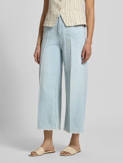 Kobiece modelka nosi Wide Leg Culotte-Jeans aus Lyocell-Baumwoll-Mix Modell 'SURI' od s.Oliver RED LABEL, jasnoniebieski denim, szerokie nogawki, wysoki stan, 5 kieszeni, frędzlowane nogawki, logo, tunel, zapięcie na guzik i ukryty zamek, lyocell-bawełna, widok całej sylwetki z przodu.