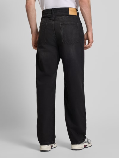 Männermodel trägt Baggy Fit Jeans im Five-Pocket-Design von REVIEW in schwarzer Waschung, lockerer Schnitt, Baumwoll-Elasthan-Mix, Ganzkörperansicht Rückansicht.