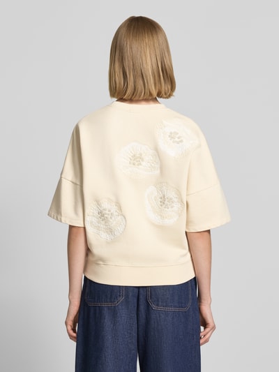 Frauenmodel trägt Sweatshirt mit 1/2-Arm Modell 'MINDULI' von Drykorn aus Reine Baumwolle mit Motiv-Stitching, Loose-Fit, Ganzkörperansicht Rückansicht.
