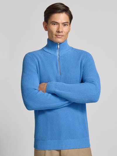 Männermodel trägt Slim Fit Strickpullover aus reiner Baumwolle mit Troyer-Kragen von MCNEAL, gerippte Abschlüsse, Ganzkörperansicht von vorne.