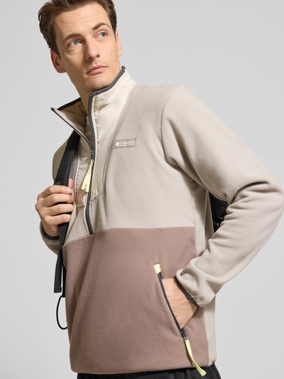 Männermodel trägt Fleecepullover mit Stehkragen und Reißverschluss von Columbia, Regular-Fit, Label-Patch, Reißverschlusstaschen, Farbkontrast, Ganzkörperansicht von vorne.