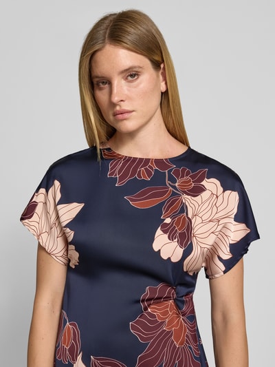 Frauenmodel trägt Midikleid aus Satin von Christian Berg Woman Selection, floraler Allover-Print in Dunkelblau und Rosa, Nahaufnahme Oberkörper.