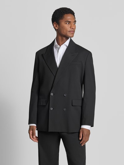 Männermodel trägt schwarzes Relaxed Fit Sakko mit Viskose-Anteil Modell 'RELAXED-LIAM' von Selected, glatte Struktur, Ganzkörperansicht von vorne.
