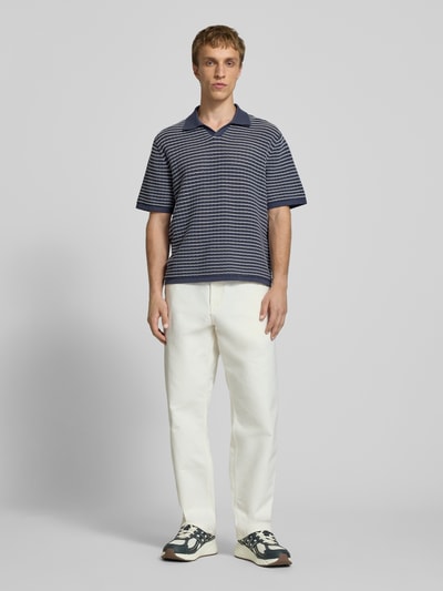 Männermodel trägt Regular Fit Poloshirt mit V-Ausschnitt von Jack & Jones aus reiner Baumwolle, Strickshirt, Ganzkörperansicht von vorne.