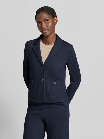 Frauenmodel trägt Blazer aus Viskose-Mix mit Reverskragen von MORE & MORE in Dunkelblau, aufgesetzte Taschen, tailliert, Ganzkörperansicht von vorne.