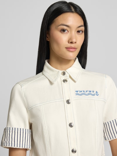 Vrouwenmodel draagt Knielanges Jeanskleid mit Stitching van Marc Cain in offwhite met blauw stitching, mix van katoen en elastaan, Overhemdkraag, Knoopsluiting, omslag aan de mouwen, detailopname bovenlichaam, borstwijdte maat 36: 46 cm, ruglengte: 90 cm, mouwlengte: 25 cm.