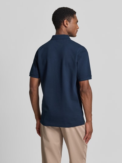 Männermodel trägt Regular Fit Poloshirt aus Baumwoll-Mix von s.Oliver RED LABEL in Dunkelblau, Ganzkörperansicht Rückansicht.