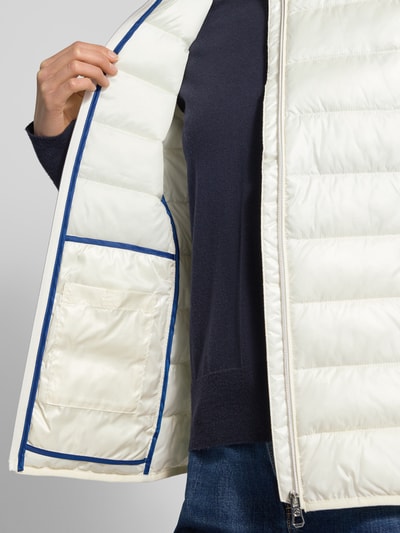 Frauenmodel trägt Steppweste mit Stehkragen von NAUTGÅRD, Regular Fit, Reißverschluss, Reißverschlusstaschen, Detailaufnahme. Rückenlänge 64 cm, Schulterbreite 35 cm, Brustweite 46 cm bei Größe S.