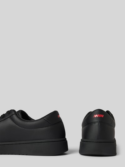 Produktfoto, Low Top Sneaker mit Label-Prägung Modell 'NESTON_TENN_PU' von HUGO in schwarzer Lederoptik mit runder Spitze und flacher Sohle, unifarbene Optik, Applikation in Rot, Kunstleder, strukturierte Sohle.