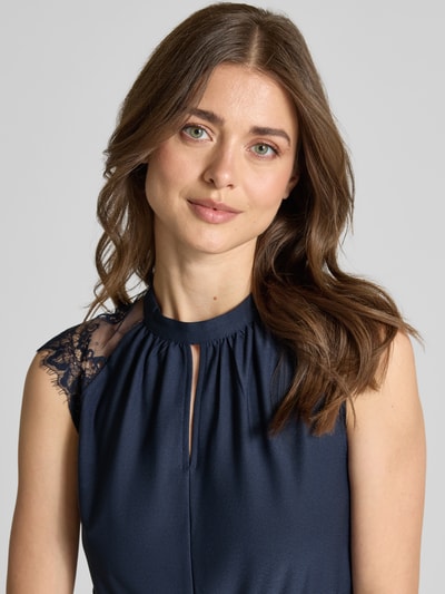 Frauenmodel trägt Tailliertes Freizeitkleid mit Spitzenbesatz Modell 'MILLA' von Vero Moda, Optik: Unifarben, Hochgeschlossen, Kurzarm, Mini-Länge, Stretch, Nahaufnahme Oberkörper.