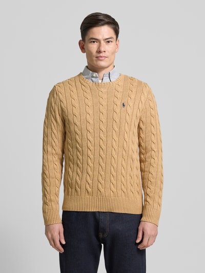 Męski model nosi Sweter z dzianiny z wyhaftowanym logo od Polo Ralph Lauren, bawełna, krój regular fit, prążkowane wykończenia, okrągły dekolt, jasnobeżowy, długość tyłu 70 cm, długość rękawa 73 cm, widok z przodu na całe ciało.