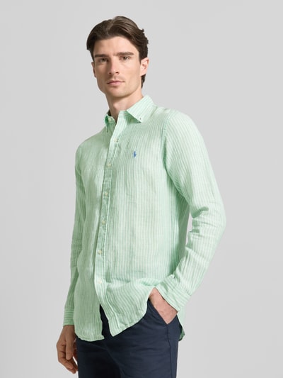 Männermodel trägt Regular Fit Freizeithemd aus reinem Leinen von Polo Ralph Lauren, hellgrün-weiß gestreift, Button-Down-Kragen, Ganzkörperansicht von vorne.