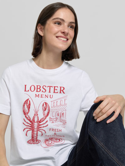 Frauenmodel trägt Damen T-Shirt mit Motiv-Print von Rich & Royal, weiße Reine Baumwolle, Regular-Fit, Rundhalsausschnitt, Ganzkörperansicht von vorne. Rückenlänge bei Größe S: 58 cm.