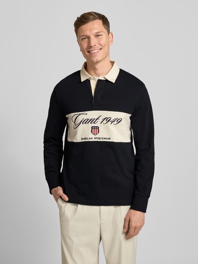 Männermodel trägt Sweatshirt mit Polokragen und verdeckter Knopfleiste von Gant, Reine Baumwolle, Regular-Fit, Label-Stitching, Ganzkörperansicht von vorne.