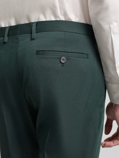 Männermodel trägt Regular Fit Stoffhose aus Satin von MCNEAL in Dunkelgrün mit Gesäßtasche, Detailaufnahme Rückansicht.