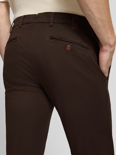 Männermodel trägt dunkelbraune Regular Fit Chino aus Baumwoll-Mix Modell 'Lupus' von MMX, glatte Struktur, Nahaufnahme Rückansicht, Herren Chino von MMX.