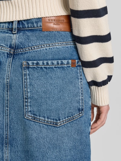 Männermodel trägt Regular Fit Jeansrock aus reiner Baumwolle Modell 'DASTI' von Weekend Max Mara, denim, z przetworzonego twillu, z naszywką z logo, krój regular fit, długość midi, 5 kieszeni, szlufki na pasek, zapięcie na guziki, widok szczegółowy tylnej kieszeni, detal tylu.