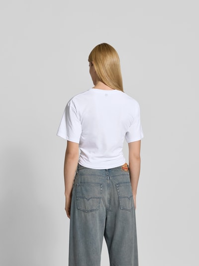 Frauenmodel trägt Cropped T-Shirt mit Zier-Detail von Rabanne, weiß, Statement-Print, elastischer Baumwoll-Mix, Ganzkörperansicht Rückansicht.