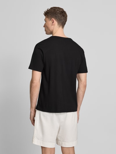 Männermodel trägt T-Shirt mit Logo und Rundhalsausschnitt von GAP in Schwarz aus Reine Baumwolle, Regular-Fit, Rückenlänge 66 cm, Ganzkörperansicht Rückansicht.