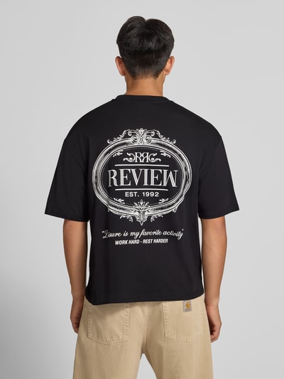 Männermodel trägt Regular Fit T-Shirt aus reiner Baumwolle mit rückseitigem Print von REVIEW, schwarze Farbe, Ganzkörperansicht Rückansicht.