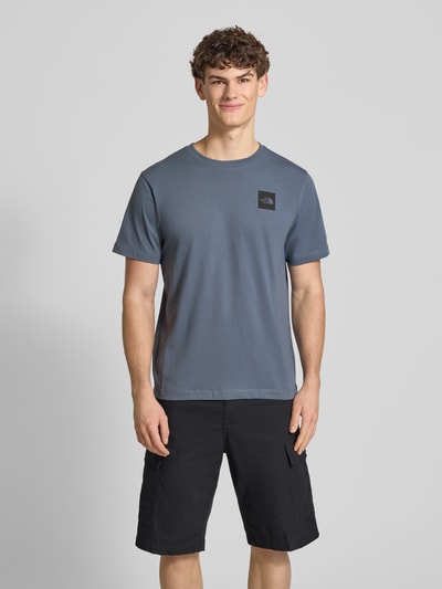 Mannelijk model draagt t-shirt uit katoenmix model 'EVOLUTION' van The North Face, regular fit, ronde hals, labelprint, ruglengte maat M 69 cm, geheelbeeld voorkant.