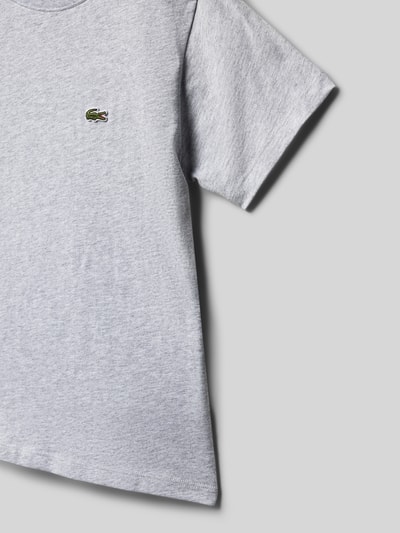 Mädchen trägt Regular Fit T-Shirt aus reiner Baumwolle von Lacoste in Melange-Optik, Label-Patch, Kurzarm, Jersey, Nahaufnahme Oberkörper.