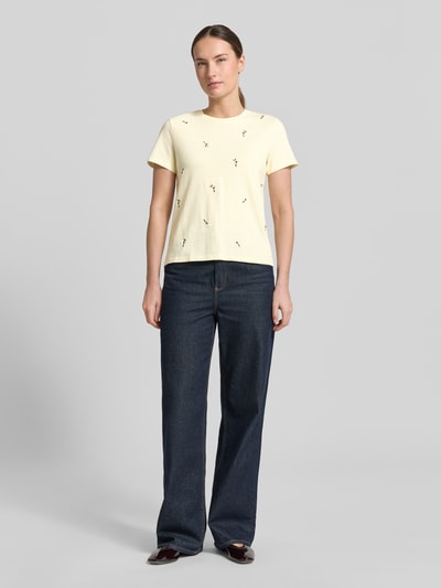 Frauenmodel trägt Regular-Fit Damen T-Shirt aus Reine Baumwolle, florales Allover-Stitching, Rundhalsausschnitt, Modell 'Flowi' von Mango, Rückenlänge bei Größe S 55 cm, Ganzkörperansicht von vorne.