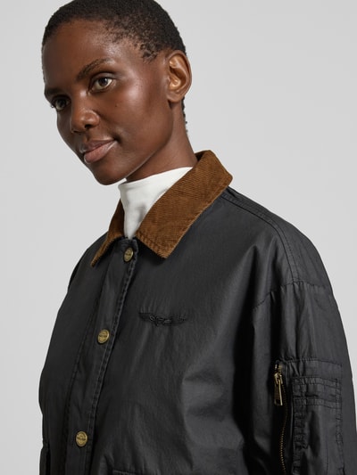 Männermodel trägt Jacke aus bawełny z kieszeniami z patką od Original Bombers, krój regular fit, wykładany kołnierz, listwa guzikowa, długość tyłu w rozmiarze S: 60 cm, szerokość ramion w rozmiarze S: 52 cm, szerokość klatki piersiowej w rozmiarze S: 58 cm, długość rękawów w rozmiarze S: 57 cm, zbliżenie na górną część ciała