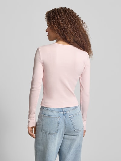Frauenmodel trägt Slim Fit Langarmshirt aus Baumwoll-Mix Modell 'FEMKE' von Only, unifarben, Feinripp, Ganzkörperansicht Rückansicht.