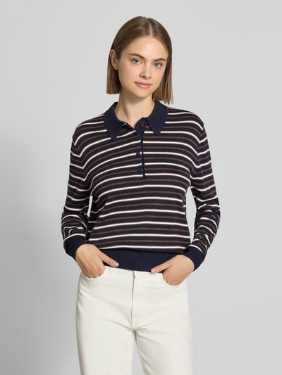 Frauenmodel trägt Poloshirt mit geripptem Saum von REVIEW, gestreiftes Design in Dunkelblau, Beige und Weiß, Baumwoll-Materialmix, gerader Schnitt, langärmlig, Polokragen, Nahaufnahme Oberkörper.