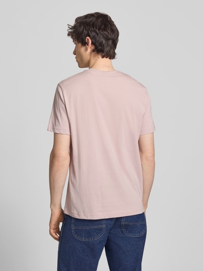 Männermodel trägt T-Shirt mit Label-Stitchings und Rundhalsausschnitt von CHAMPION in Rosa, Reine Baumwolle, Regular-Fit, Rückenlänge 66 cm, Ganzkörperansicht Rückansicht.