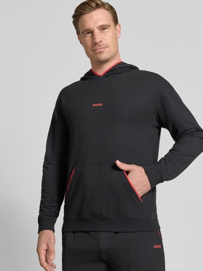 Männermodel trägt Regular Fit Hoodie aus Baumwoll-Mix Modell 'NOAH' von HUGO in Schwarz mit roten Akzenten, Herren T-Shirt von HUGO, Nahaufnahme Oberkörper