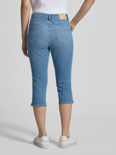 Frauenmodel trägt Slim Fit Caprijeans aus Baumwoll-Mix Modell 'BETSY' von s.Oliver RED LABEL in hellem Denim, Mid Waist, 5-Pocket-Design, Ganzkörperansicht Rückansicht.