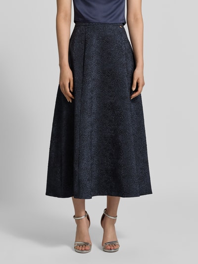 Vrouwenmodel draagt Midirok met structuurpatroon van Rinascimento, donkerblauw, A-lijn, elastische materiaalmix, naadritssluiting, bandwijdte maat S 35 cm, totale lengte maat S 90 cm, volledig zichtbaar van voren.
