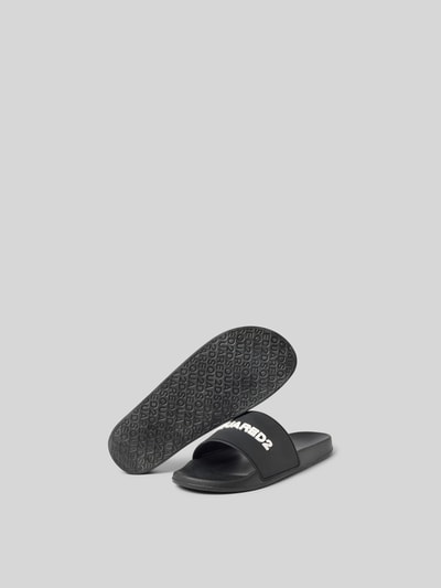 Produktfoto, Slides mit Label-Detail von Dsquared2 in Schwarz mit abgerundeter Form, offener Ferse und glatter Sohle, Absatzhöhe 3 cm.
