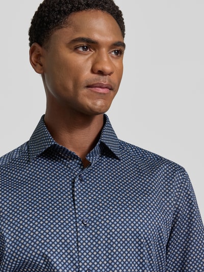 Männermodel trägt Modern Fit Businesshemd aus reiner Baumwolle von OLYMP, fein gemustertes Design in Blau, Nahaufnahme Oberkörper, Herren Businesshemd von OLYMP.