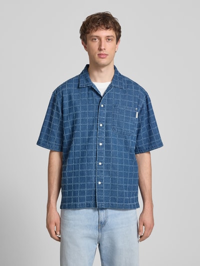 Männermodel trägt Oversized Freizeithemd in Denim-Optik Modell 'Elton' von Redefined Rebel, reine Baumwolle, Kentkragen, Ganzkörperansicht von vorne.