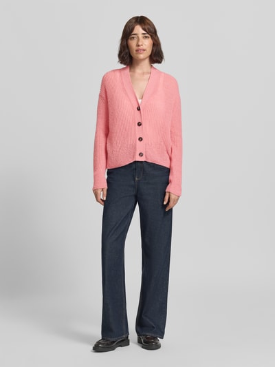 Frauenmodel trägt Strickjacke aus Alpaka-Mix mit V-Ausschnitt von Closed in Rosa, strukturierte Oberfläche, Knopfleiste, Relaxed Fit, Ganzkörperansicht von vorne.