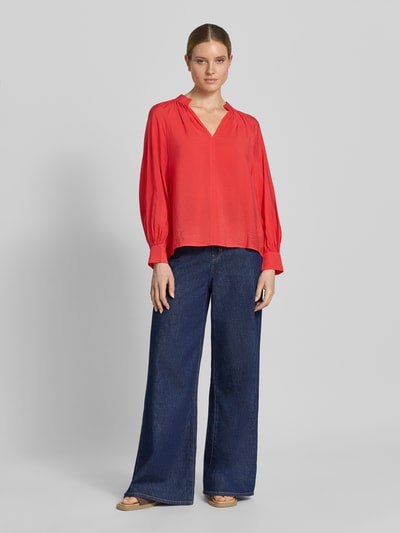 Frauenmodel trägt Bluse aus Viskose-Mix mit Serafino-Ausschnitt von Christian Berg Woman in Rot, lockere Passform, Ganzkörperansicht von vorne.