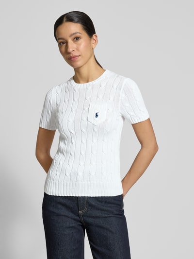Modelka kobieca nosi Slim Fit Kurzarmpullover mit Label-Stitching od Polo Ralph Lauren, biała bawełna, krój slim fit, struktura dzianinowa, kieszeń na piersi z logo, okrągły dekolt, elastyczne wykończenia, widok całej sylwetki z przodu.