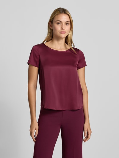 Frauenmodel trägt Bluse aus Satin mit Rundhalsausschnitt von Rinascimento, bordeauxrot, glatte Textur, kurzärmelig, Material-Mix mit Stretch-Anteil, ganzkörperansicht von vorne.