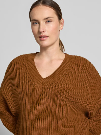 Frauenmodel trägt Regular Fit Pullover aus Baumwoll-Mix Modell 'SELMA' von Selected in warmem Braun, grobe Strickstruktur, Nahaufnahme Oberkörper, Damen Pullover von Selected.