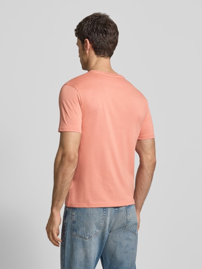 Männermodel trägt Regular Fit T-Shirt mit Logo-Stitching von Scotch & Soda aus reiner Baumwolle in Rosa, Rückenansicht, Ganzkörperansicht Rückansicht.